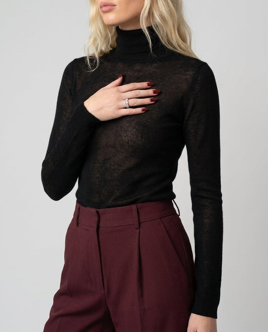 Bluză transparentă neagră din cașmir pentru damă, Made in Italy, cu croială lejeră și material fin, moale și confortabil, ideală pentru ținute elegante, casual chic și office. Bluză damă premium cu efect discret transparent, perfectă pentru a fi purtată peste un top, alături de pantaloni eleganți, jeanși, fuste sau sacouri, potrivită pentru orice sezon.
