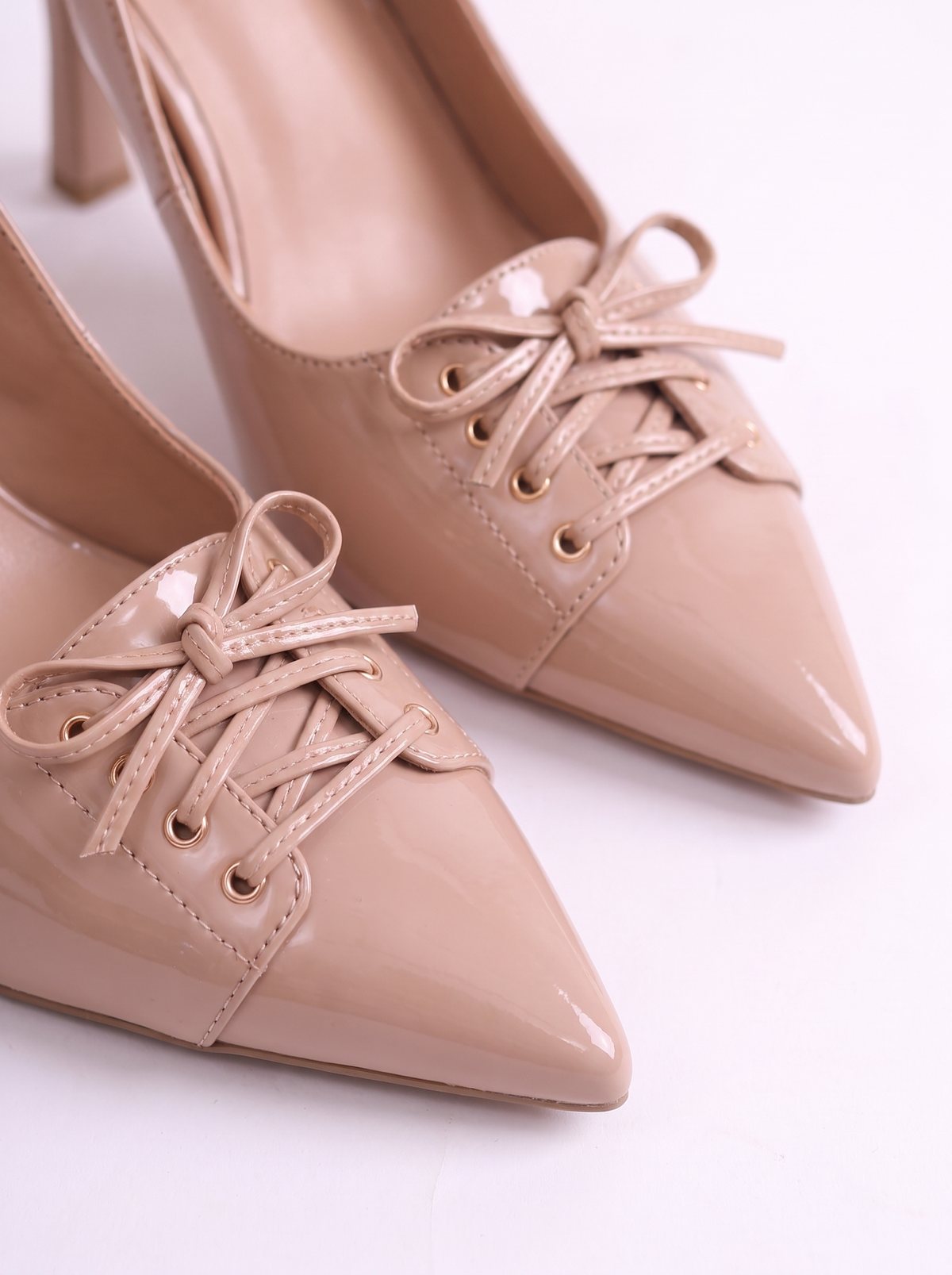 Prim-plan cu pantofi nude pentru femei, model slingback cu vârf ascuțit, toc înalt de 9 cm și detaliu decorativ cu șiret, realizați într-un design elegant și modern, potriviți pentru evenimente festive și ținute sofisticate.