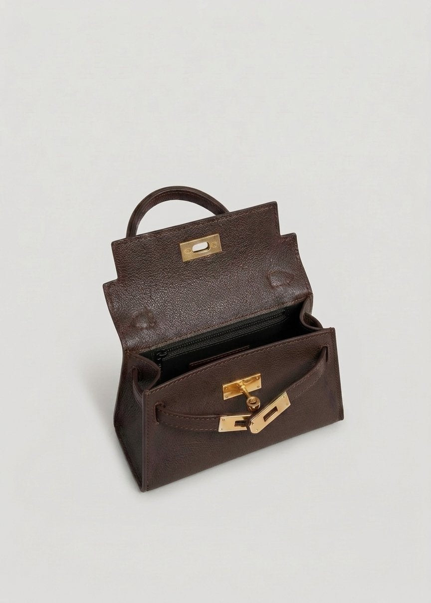 Poșetă maro închis pentru femei din piele naturală Made in Italy, cu design modern, închidere metalică twist-lock și curea detașabilă. Geantă premium pentru damă, perfectă pentru outfituri elegante, business, casual și evenimente speciale.