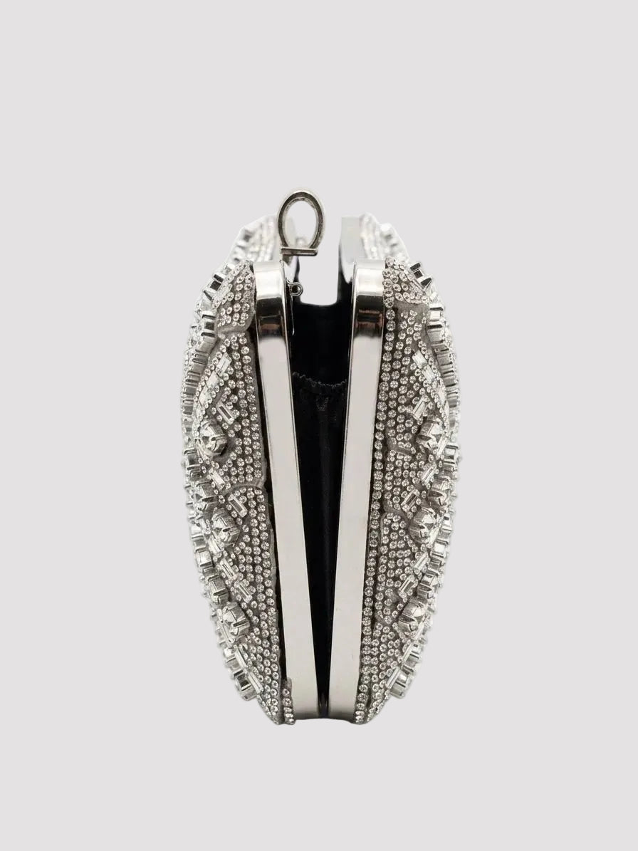 Poșetă damă argintie tip clutch, împodobită cu strass și cristale strălucitoare, cu design geometric modern și lanț metalic premium, accesoriu elegant recomandat pentru nunți, botezuri, petreceri, banchete și alte ocazii speciale.