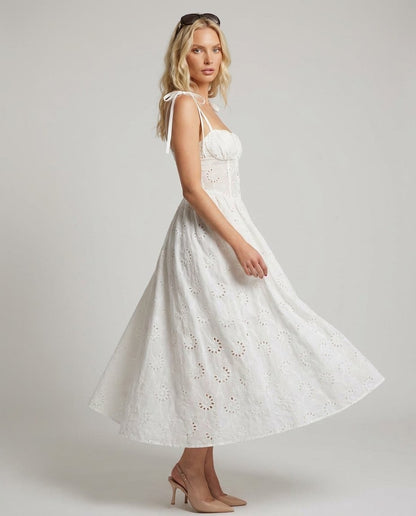 Rochie albă elegantă pentru damă din dantelă brodată Made in Italy, cu bretele tip fundă, croială feminină și fustă amplă. Rochie midi de vară pentru femei, ideală pentru petreceri, garden party, vacanțe, city break, plajă și evenimente elegante de zi.
