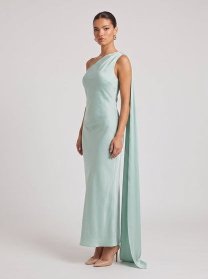 Rochie maxi verde mentă pentru femei, cu design pe un umăr, eșarfă lungă decorativă și croială elegantă care evidențiază silueta. Rochie de seară pentru damă, ideală pentru petreceri, recepții, ceremonii, aniversări și ținute rafinate.
