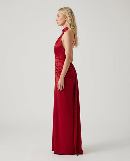 Rochie lungă roșie de seară pentru damă, cu croială mulată, decolteu halter și drapaje elegante în zona taliei, realizată din material elastic și confortabil. Rochie premium pentru femei, recomandată pentru nunți, baluri, cocktail-uri, Revelion și evenimente festive.