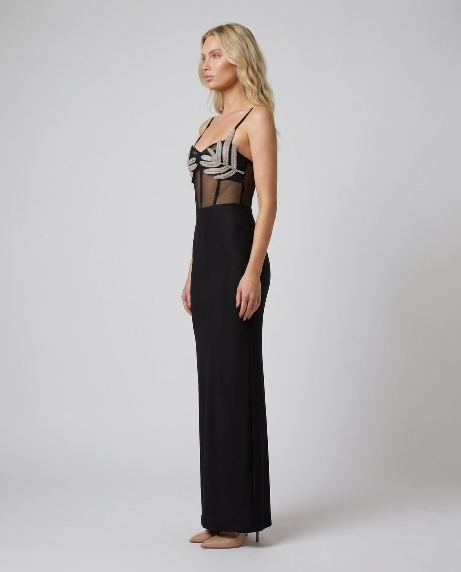 Rochie maxi neagră de seară pentru femei, cu aplicații luxoase din cristale în formă de frunze și inserții transparente elegante care evidențiază silueta. Rochie de ocazie pentru damă, ideală pentru recepții, petreceri elegante, cocktail-uri și ceremonii.