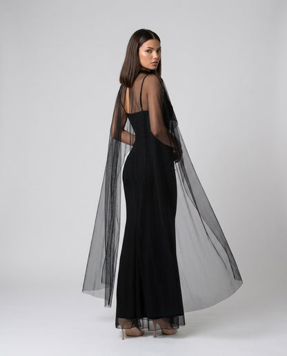 Rochie lungă neagră de ocazie pentru damă, cu croială mulată, detalii din voal transparent și material elastic care oferă confort și evidențiază armonios silueta. Rochie premium pentru femei, recomandată pentru nunți, baluri, Revelion și evenimente festive.