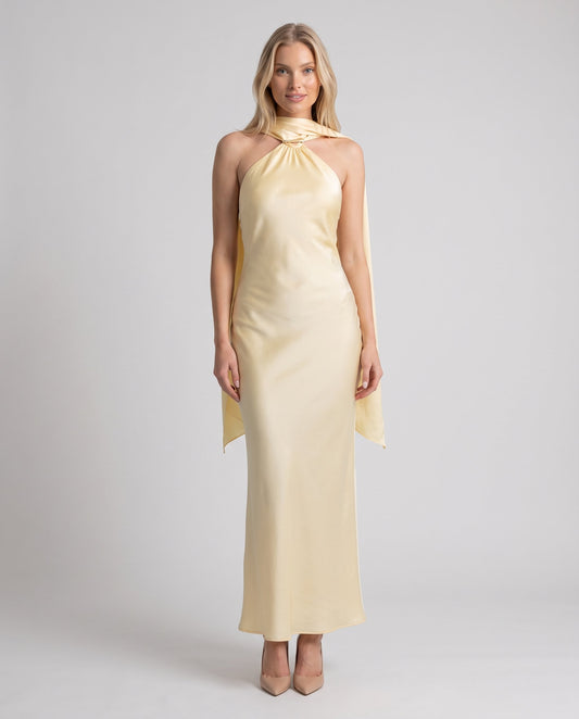Rochie lungă satinată galbenă pentru damă, cu decolteu halter și eșarfă fluidă elegantă, perfectă pentru nunți, botezuri, gale, baluri, cocktail-uri și evenimente speciale. Rochie de ocazie pentru femei cu design sofisticat, croială maxi și aspect luxos.