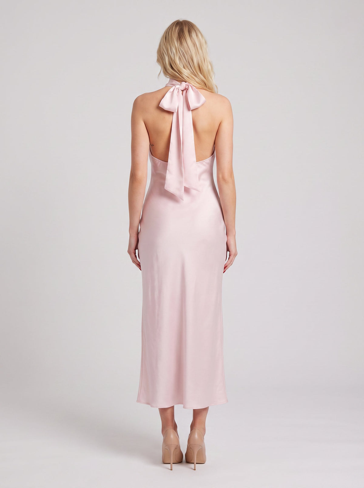 Rochie maxi roz pudră din satin pentru femei, cu decolteu halter feminin și material fin cu aspect mătăsos, ideală pentru petreceri elegante, recepții, ceremonii, aniversări și ocazii speciale. Rochie de seară premium pentru damă.