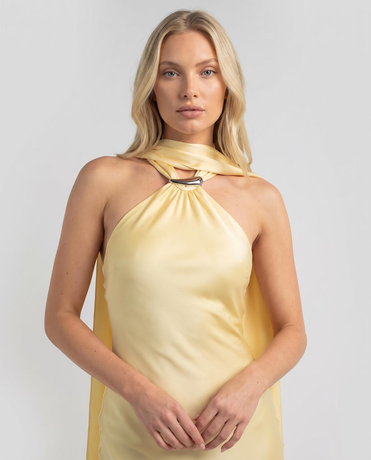 Rochie maxi galbenă satinată pentru femei, cu decolteu halter, eșarfă integrată și croială feminină care evidențiază silueta. Rochie elegantă de seară pentru damă, ideală pentru petreceri, aniversări, recepții, ceremonii și ținute glamour.