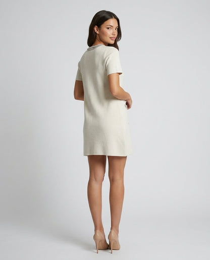 Rochie elegantă crem pentru femei, realizată din material tricotat fin, cu buzunare decorative și aplicații din cristale care completează un design modern și sofisticat. Rochie pentru damă, potrivită pentru ținute office, casual elegante și întâlniri.