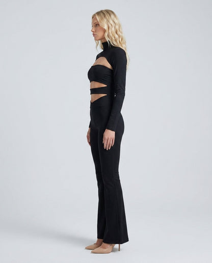 Set negru 3 piese pentru femei, cu pantaloni lungi evazați, top decupat și bolero asortat, realizat din material elastic care urmărește armonios linia corpului. Compleu damă perfect pentru petreceri, aniversări, concerte, club și outfituri moderne de seară.