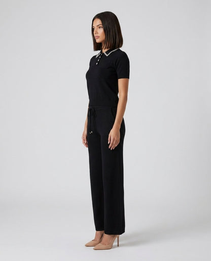Set tricotat negru pentru femei, format din bluză cu aplicații strălucitoare și pantaloni lungi evazați cu talie elastică, realizat din material premium moale și confortabil. Compleu casual elegant pentru damă, perfect pentru activități zilnice și evenimente de zi.
