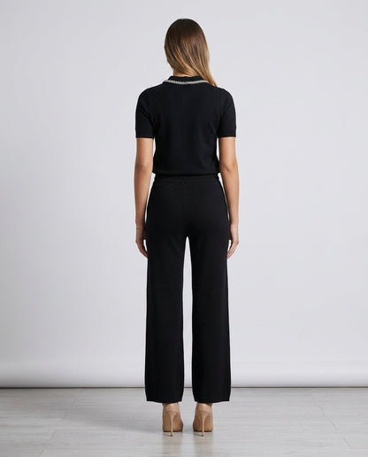 Compleu premium negru pentru damă, realizat din tricot fin, cu bluză modernă decorată cu cristale și pantaloni evazați care oferă confort și eleganță. Set pentru femei, ideal pentru office, city break, vacanțe, plimbări și garderoba casual chic.