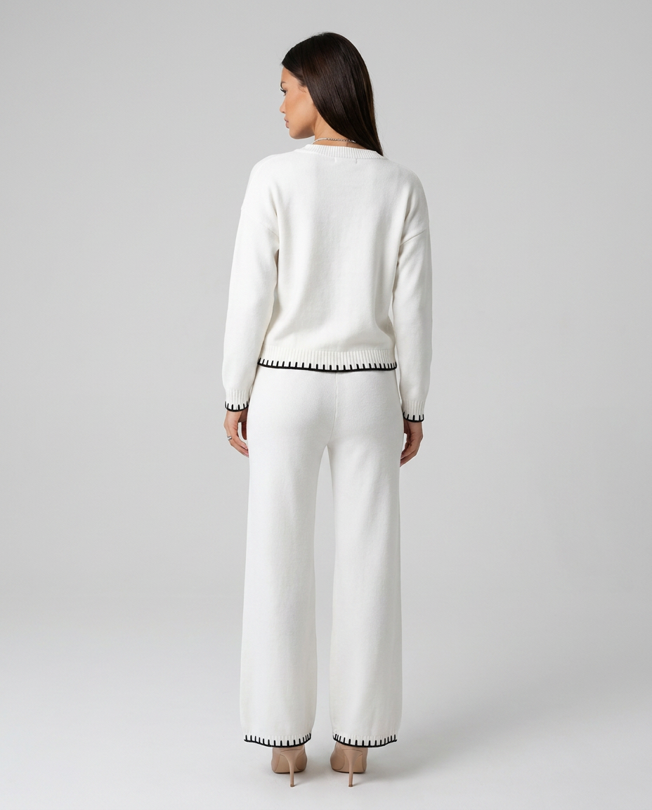 Compleu tricotat alb de damă cu bluză lejeră și pantaloni lungi confortabili, finisaje contrastante și material moale premium, perfect pentru ținute casual chic, relaxare, birou în stil smart casual, vacanțe și ieșiri în oraș.